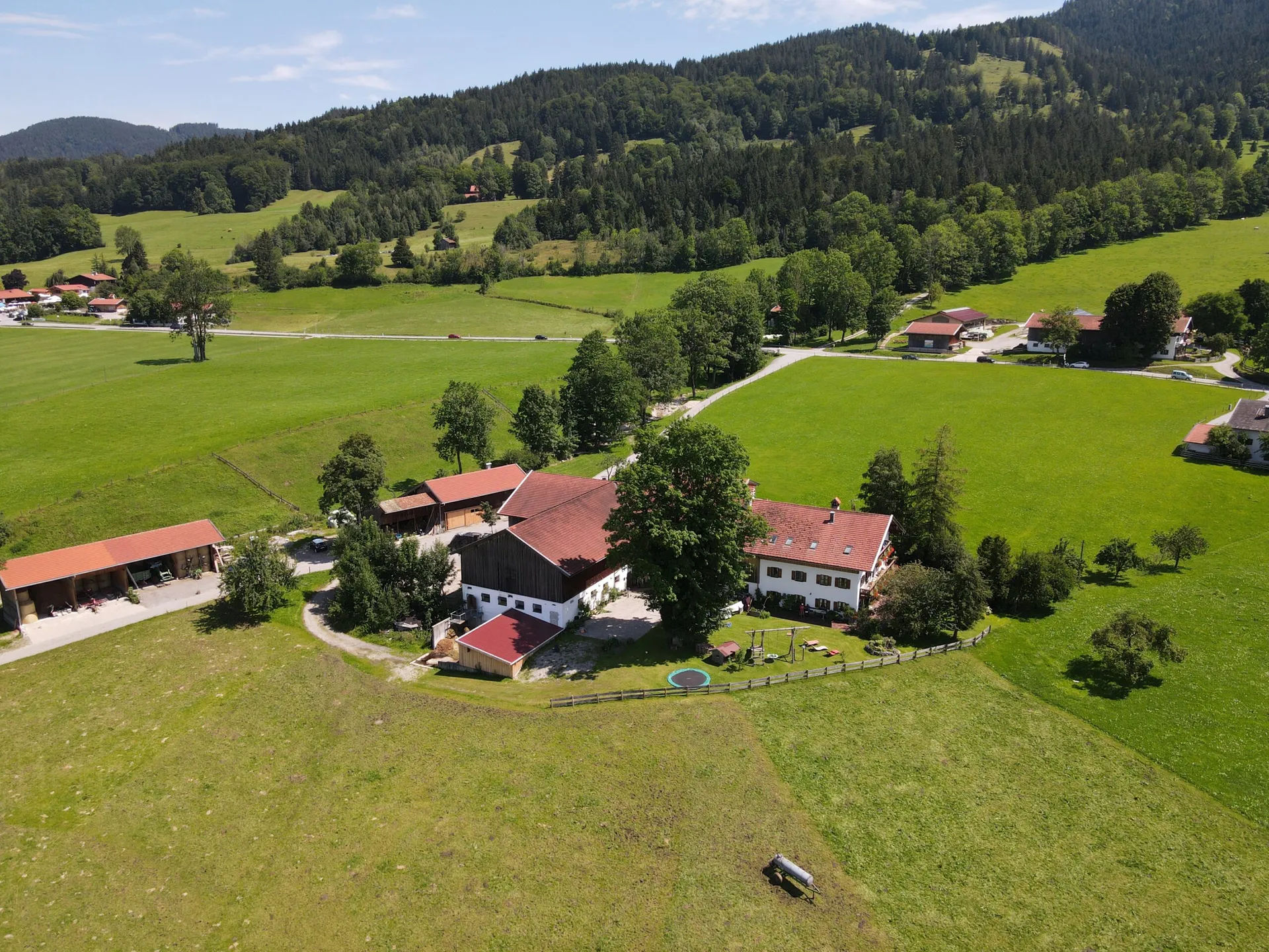 Luftbild des Koanhofs eingebettet in grüne Wiesen und Berge