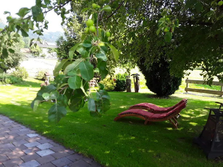 Garten mit Liege unter Bäumen