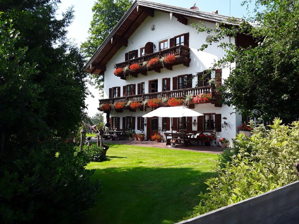 Das Bauernhaus des Koanhofs mit blühenden Balkonen und Bergblick